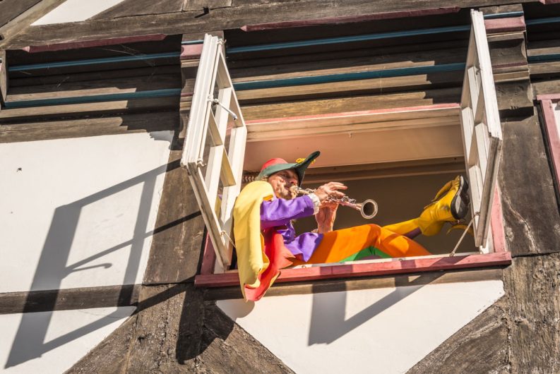 Der Hamelner Rattenfänger beim Spiel mit der Flöte in einem Fenster sitzend